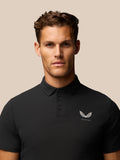 Close-up of the black Golf Club Essential Polo front with Castore logo on the left chest
