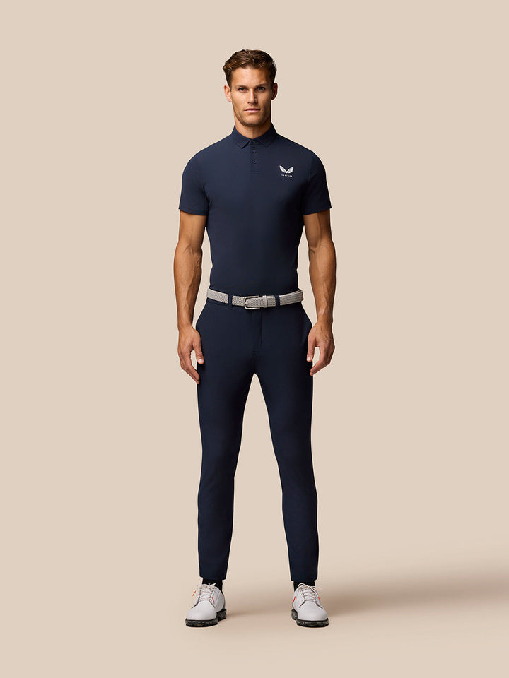 Back shoulder close-up of navy Golf Club Essential Polo highlighting vertical CASTORE branding.