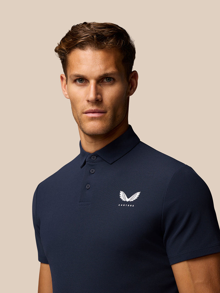 Front view of navy Golf Club Essential Polo for men with Castore logo on left chest and three-button placket.