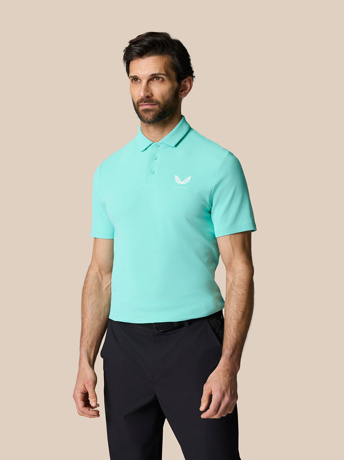 Front view of a man wearing a light aqua Golf Club Essential Polo with a white Castore logo on the chest