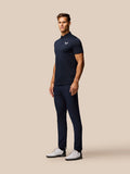 Male model wearing a navy striped golf polo with three button placket and Castore logo on the chest