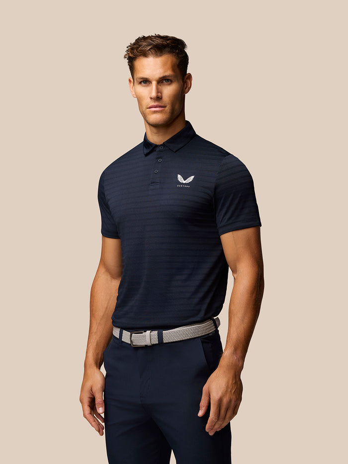 Man wearing a navy striped golf polo with a polo collar and three-button placket Castore logo on the chest