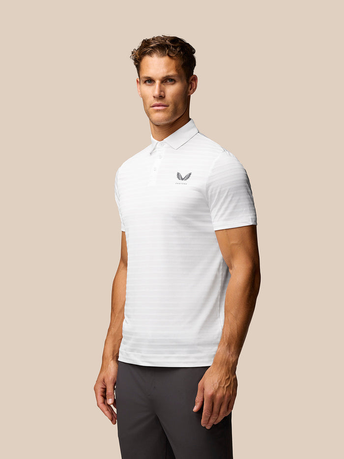 Male model wearing white striped golf polo with Castore logo on left chest and upper back