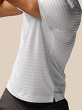 Close-up of back hem showing a small side slit on the white striped polo