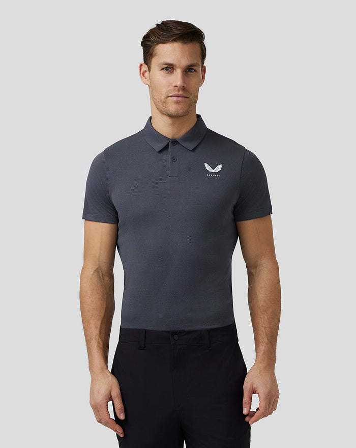 Male model in a dark grey Castore Golf Pinnacle Engineered Polo with a three button placket and chest logo.