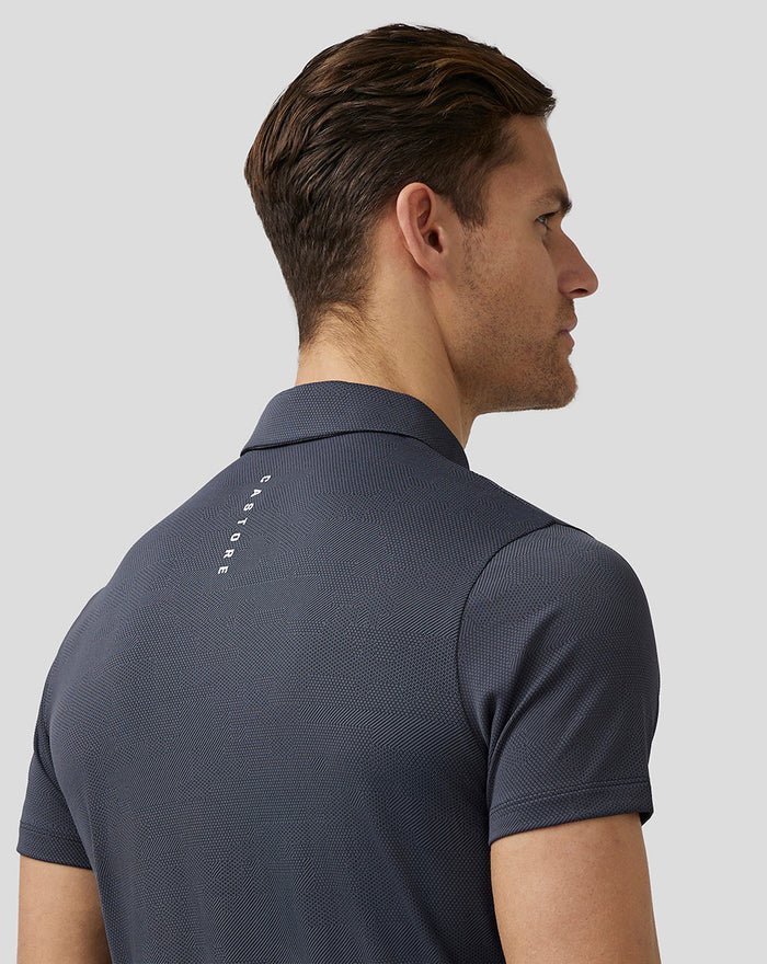 Back view of a gray Castore Golf Pinnacle Engineered Polo on a male model, showcasing textured knit fabric.