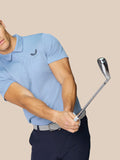 Achteraanzicht van een man in een hemelsblauwe Golf Pinnacle Polo met Castore-logo op de bovenrug.