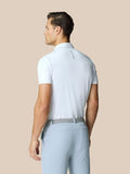 Rear view of a male model in a white Golf Pinnacle Polo with Castore logo on the upper back, paired with light blue pants.