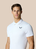 Back view of a man in a white polo with Castore logo on the upper back