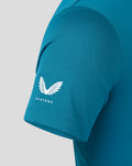 Close-up of teal Pinnacle engineered knit golf polo with textured knit and Castore wing logo on the chest