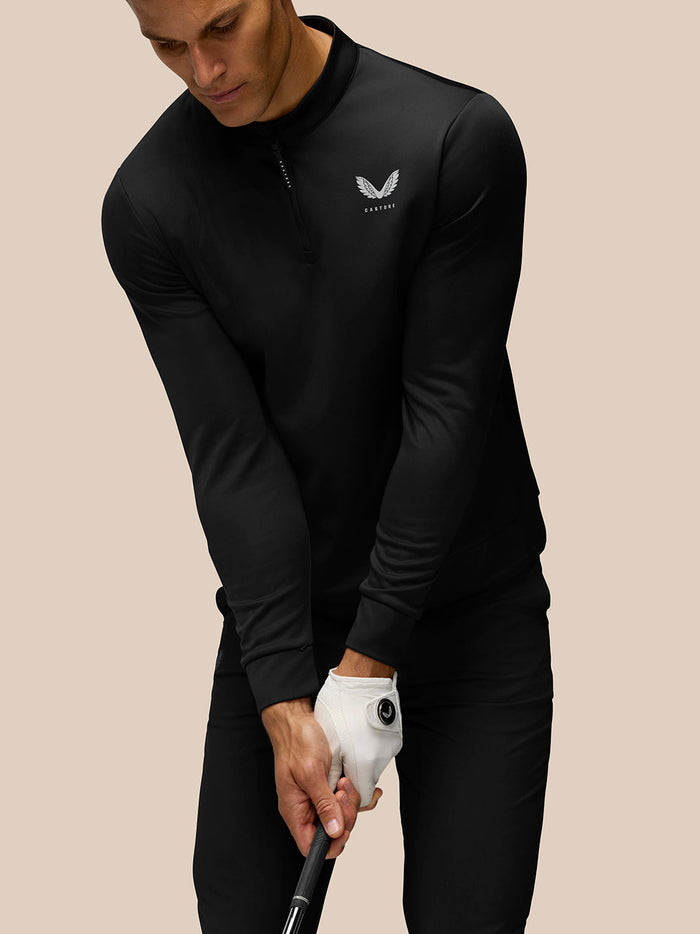 Back of black golf top with vertical Castore lettering along the spine