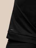 Close up of black golf top fabric with Protek branding near the hem.