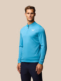 Man in blauw lange mouw Golf Club Classic Top met kwart-rits en donkerblauwe broek op de golfbaan