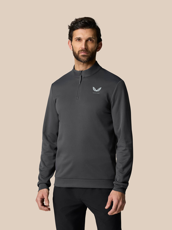 Gunmetal Golf Club Classic Quarter Zip Top on a male model with a stand collar, long sleeves, Protek water resistance, and Castore logo on chest.