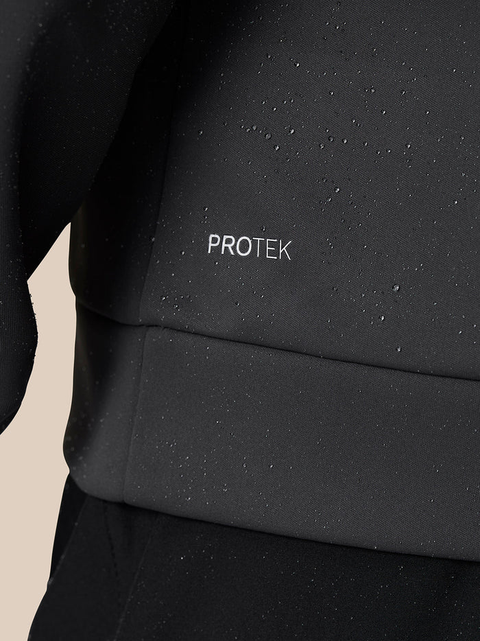 Close up of black Protek fabric with water droplets on a Castore golf top