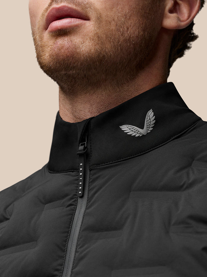 Close up of a black jacket collar with a Castore wing logo and front zipper