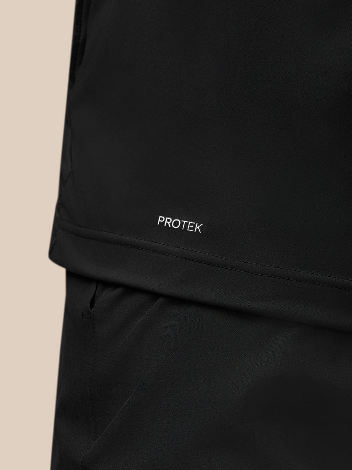 Detail van het PROTEK label op de zoom van de zwarte gilet.
