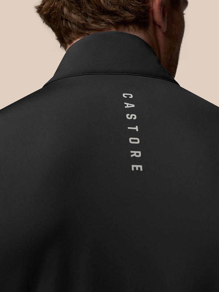 Back view of a black Golf Pinnacle Gilet showing vertical Castore branding along the back
