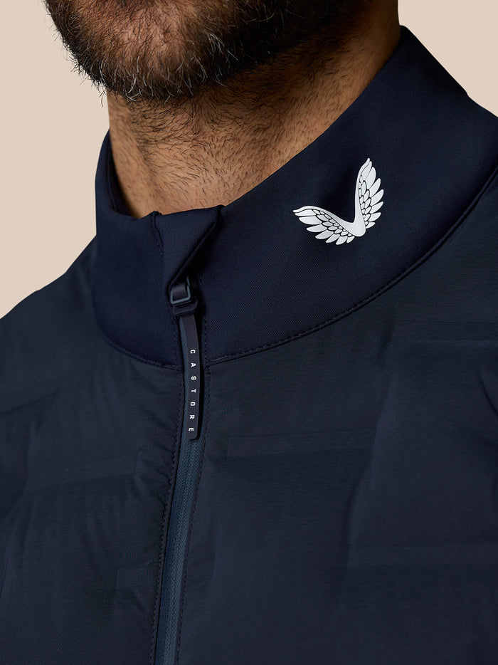 Close-up of navy Pinnacle gilet collar with white wing logo and front zipper
