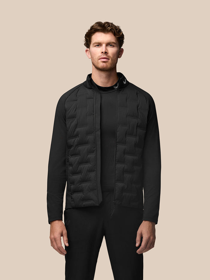 Front view of a man wearing a black Golf Pinnacle Jas jacket with quilted front panels and a full-length zipper