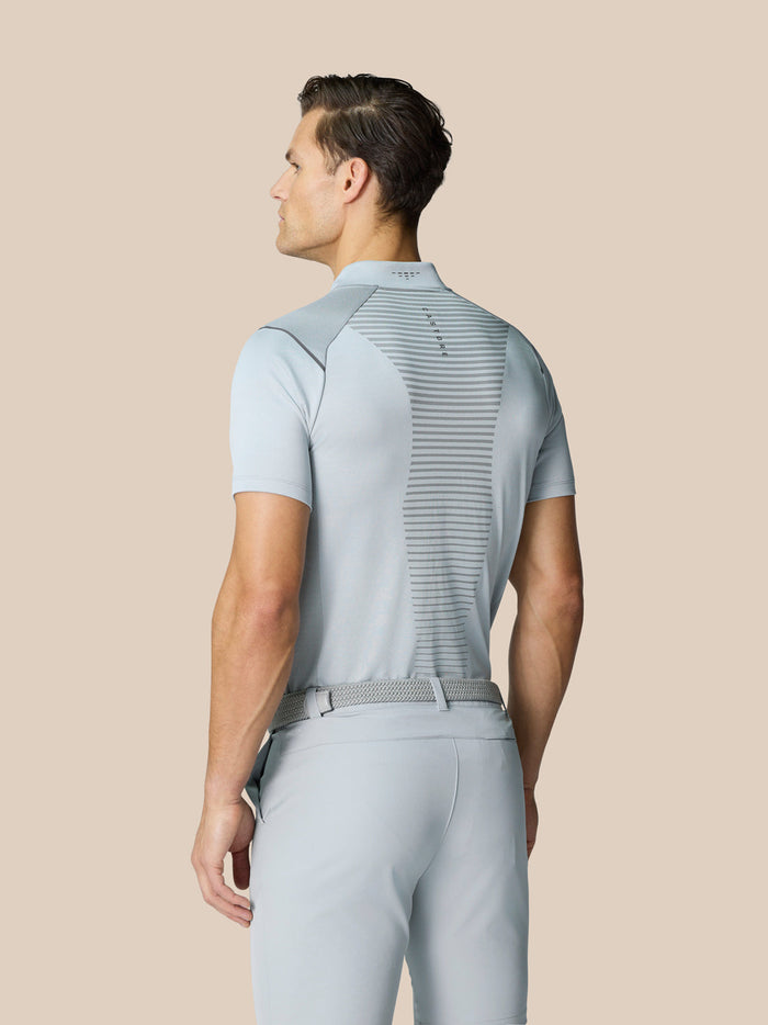 Back view of a male model wearing the Pinnacle Golf Polo in light grey with vented back panel design