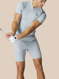 Athletic golfer wearing the Pinnacle Golf Polo in mid grey, visible striped chest pattern and logo on the chest