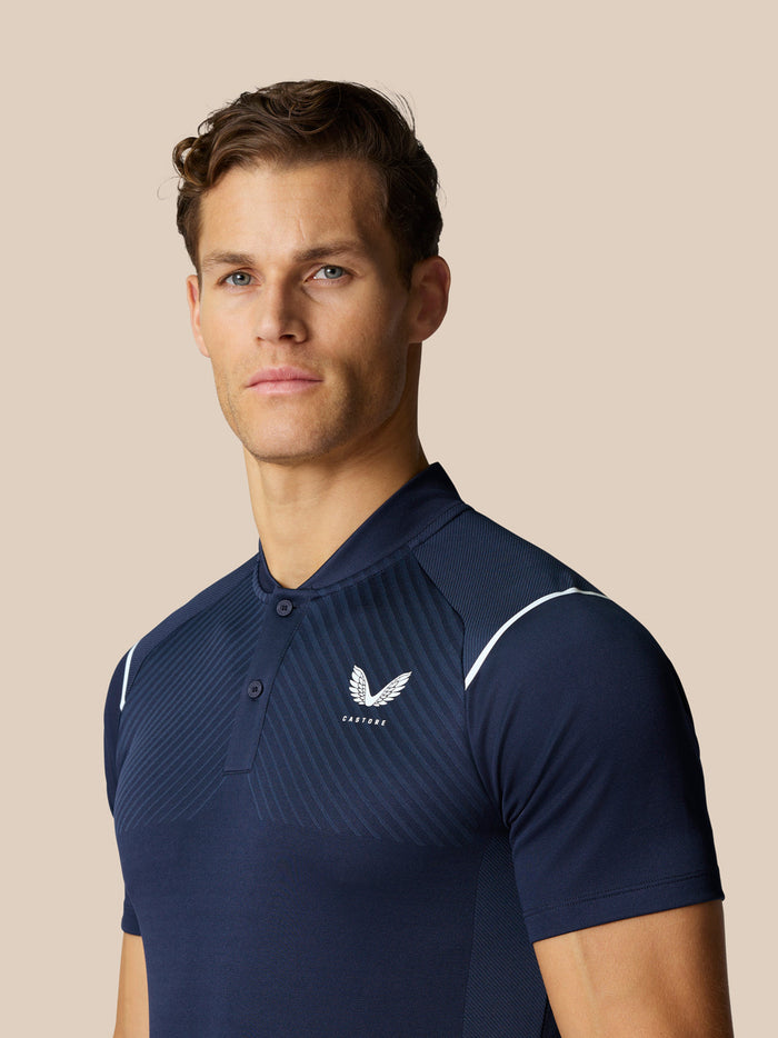 Man wearing marine blue Pinnacle Golf Polo with subtle diagonal stripes and a white wing logo on the chest