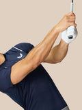 Golfer in marineblauw Pinnacle Golf Polo maakt een backswing met een witte handschoen tegen een beige achtergrond