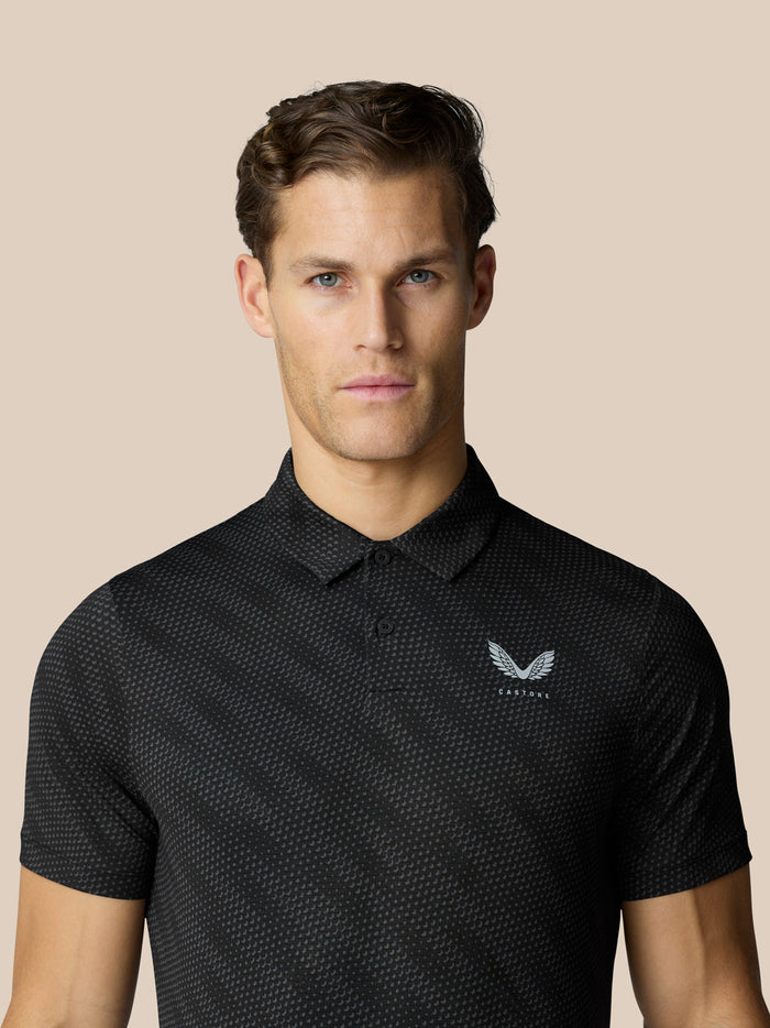 Man wearing black textured golf polo with a subtle dot pattern and Castore logo on the chest
