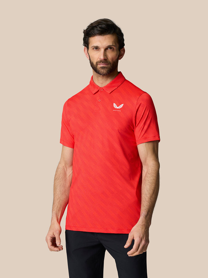 Male model in a red Golf Club Grafische Polo with a white logo on the chest and upper back, beige background.