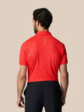 Back view of a man in a red graphic golf polo with a vertical Castore logo down the spine
