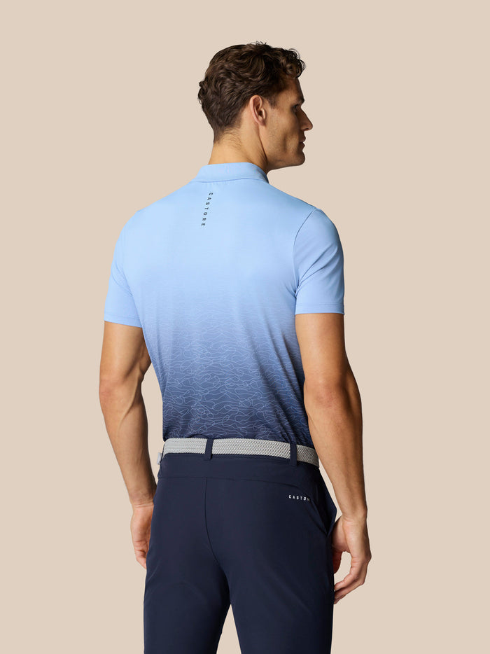 Achteraanzicht van model in hemelsblauwe Club Golf Grafische Polo met ombre print en Castore-logo op de rug