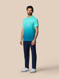 Volledig beeld van een man in Club Grafische Polo Licht Aqua met marineblauwe broek en witte schoenen.