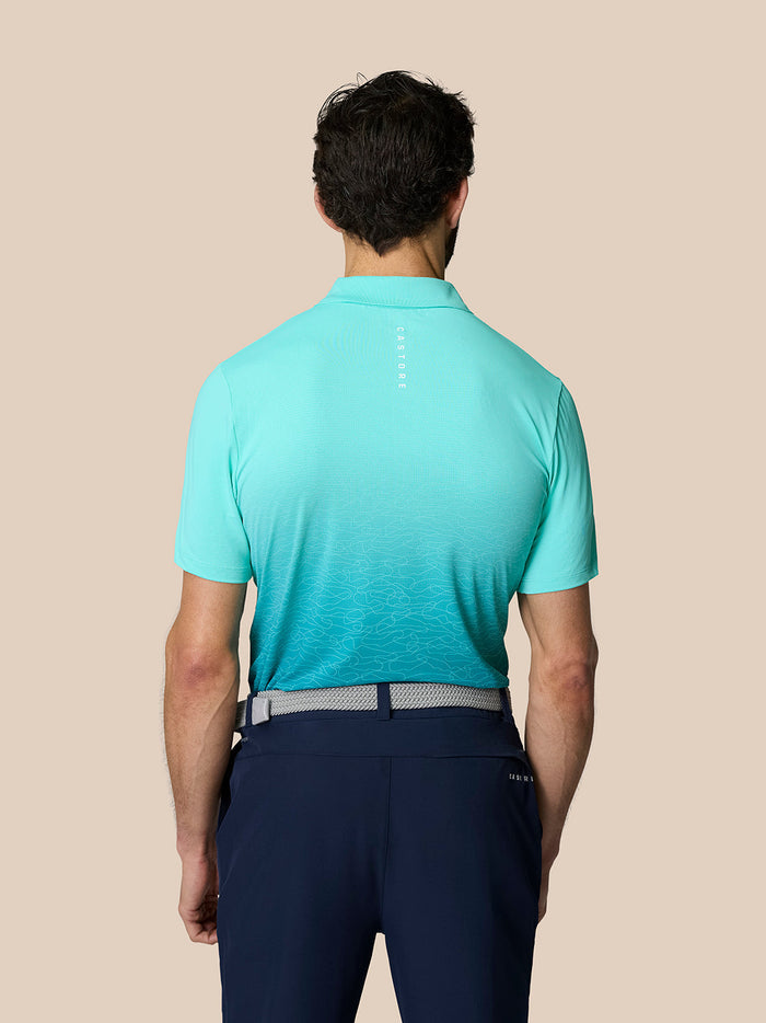 Back view of Club Grafische Polo Licht Aqua with a vertical Castore logo on the upper back and an ombre graphic.
