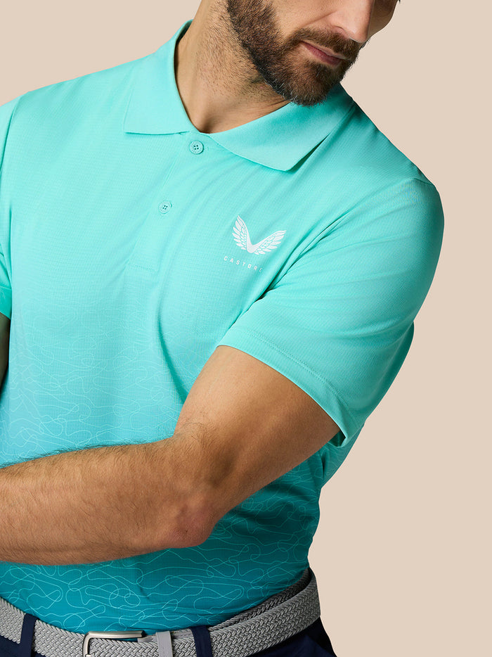Close up of Club Grafische Polo Licht Aqua with a white Castore logo on the left chest and breathable fabric.