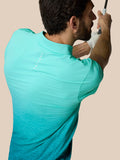 Achteraanzicht van model in Club Grafische Polo Licht Aqua met ombre patroon en Castore-logo op de bovenrug.