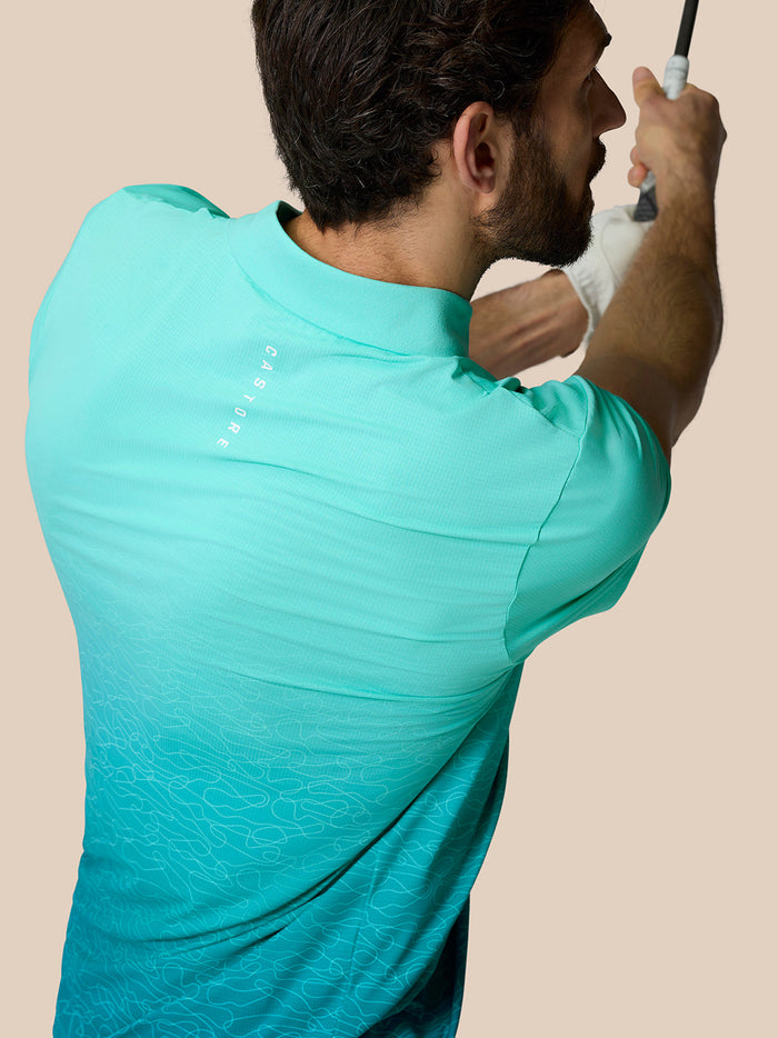 Achteraanzicht van model in Club Grafische Polo Licht Aqua met ombre patroon en Castore-logo op de bovenrug.