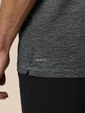 Close up of dark Club Grafische Polo fabric showing an abstract light gray squiggle print and AERTEK branding at the hem