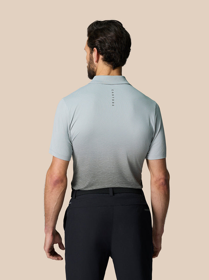 Back view of a model in the light gray polo showing the Castore logo on the upper back