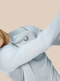 Model draagt Golf Pinnacle Kwartrits Top LVS ¼ rits in mid grijs met diagonale borststroken en ademende knit panels