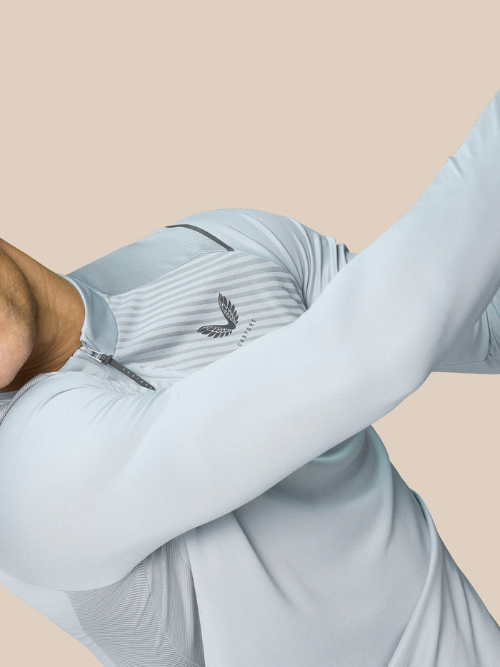 Model draagt Golf Pinnacle Kwartrits Top LVS ¼ rits in mid grijs met diagonale borststroken en ademende knit panels