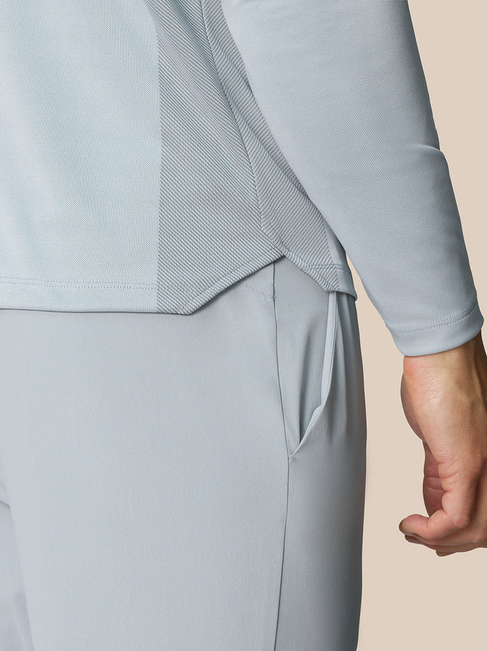 Close up of the back hem and vent panel on the light gray LVS golf top