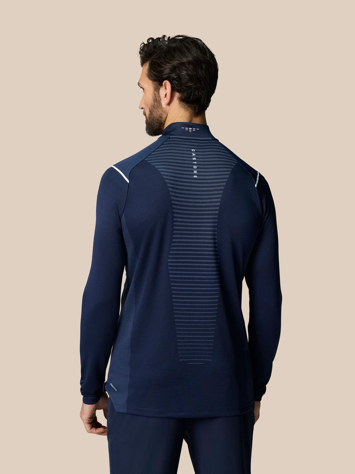 Achterkant van marineblauwe golf top met rugventilatie en verticale Castore branding bij de nek