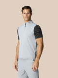 Male model wearing a light grey Club Halve Zip Gilet with high collar against a beige background
