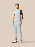 Full body shot of a man in a light grey half zip gilet with matching pants and white golf shoes