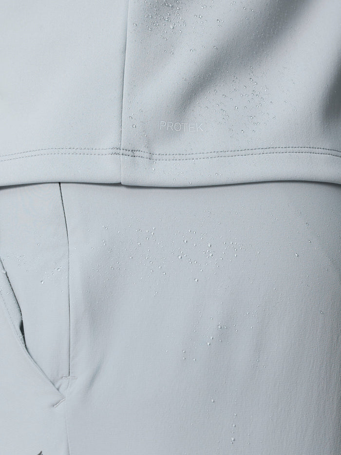Close-up of light gray fabric with water droplets showing ProTek water repellency.