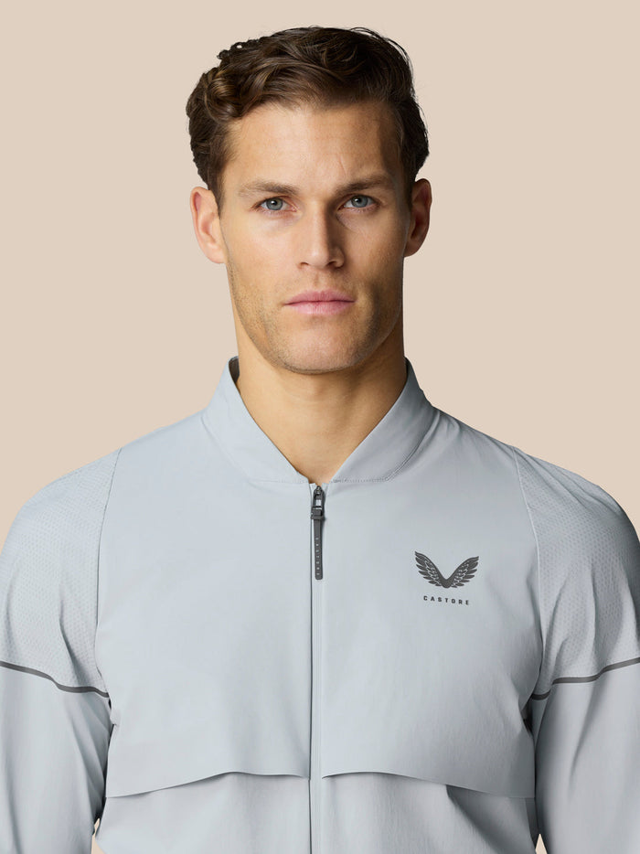 Front view of a man wearing a light gray Golf Pinnacle woven jacket.