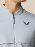 Front chest of the gray Golf Pinnacle woven jacket with a center zipper and Castore logo.