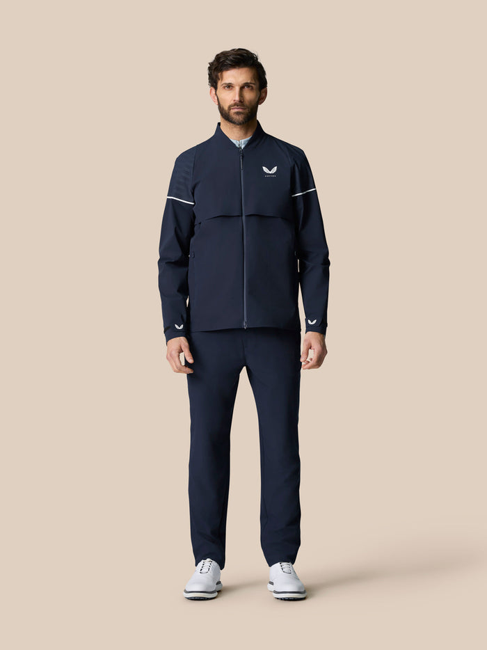 Male model wearing a navy Golf Pinnacle woven jacket with full zip and ventilated panels