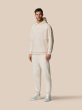 Volledig vooraanzicht van man in oatmeal marl fleece hoodie met wikkelkapuchon en Castore logo op de borst.
